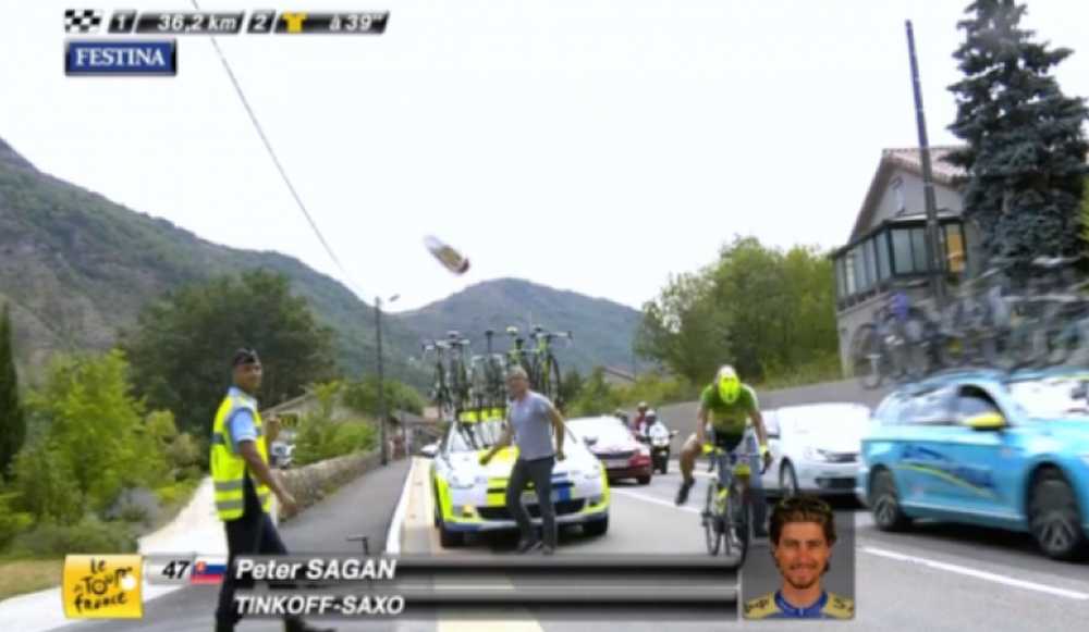 Faustino Muñoz mecánico del Tinkoff-Saxo lanza un bidón a una moto de TV
