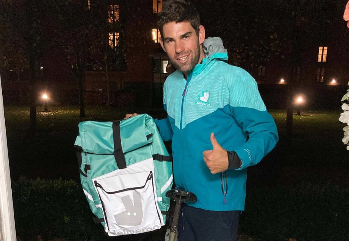 Joe Skipper posando con su bicicleta de carretera y su mochila de Deliveroo realizando una de sus entregas de comida a domicilio de esta pretemporada.